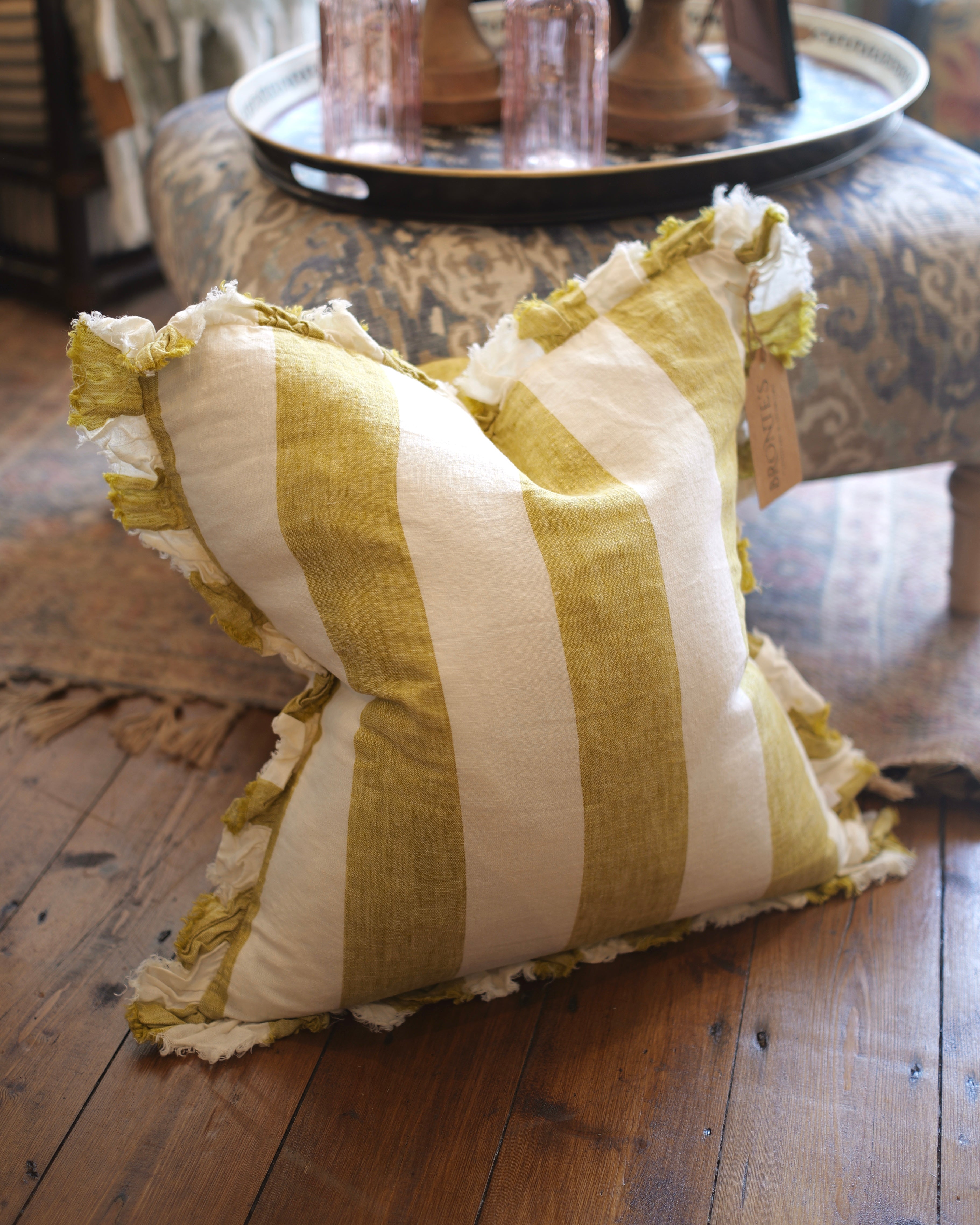 Striped pillow with ruffled edges on a wooden floor
