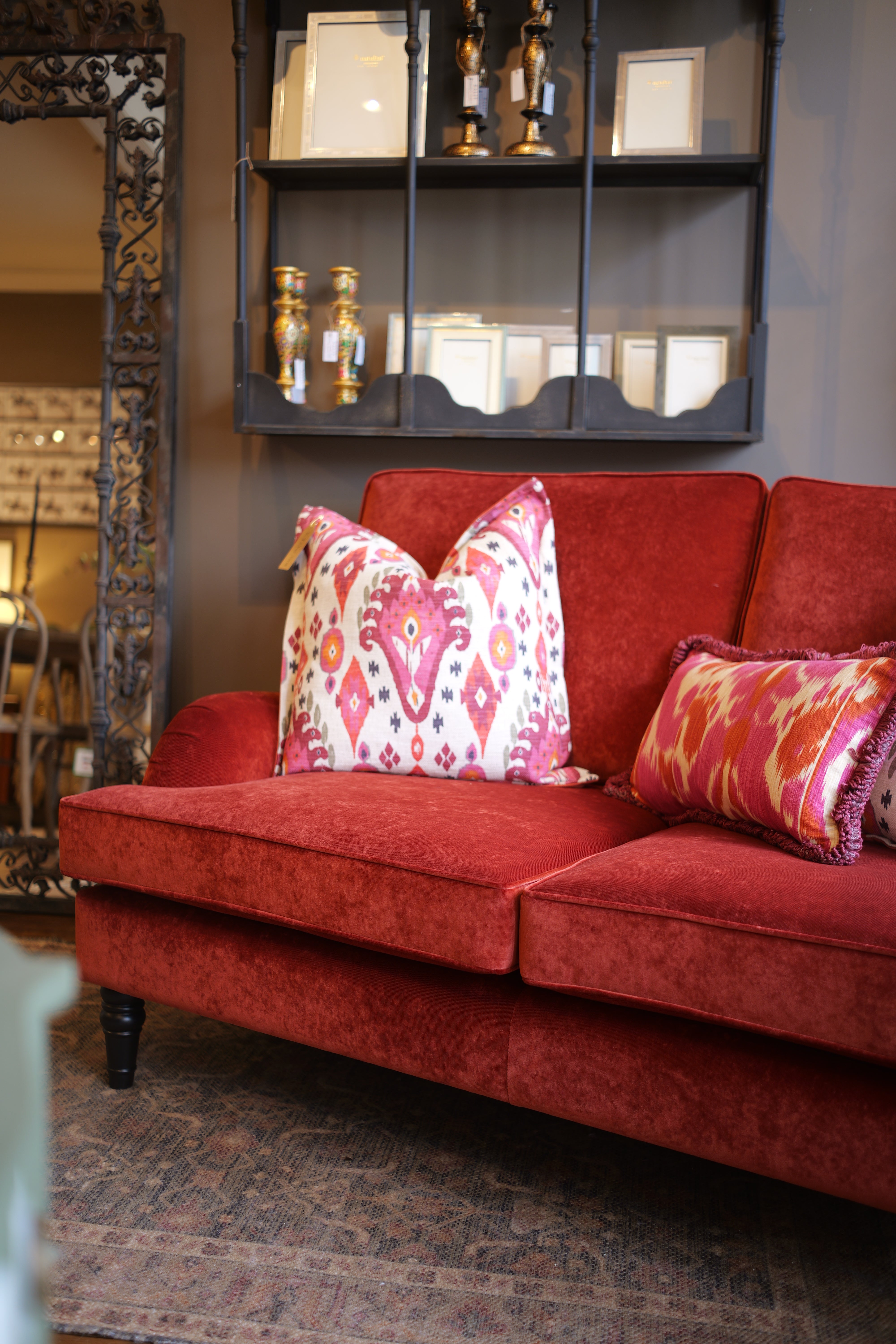 Red sofa with patterned cushions in a room setting