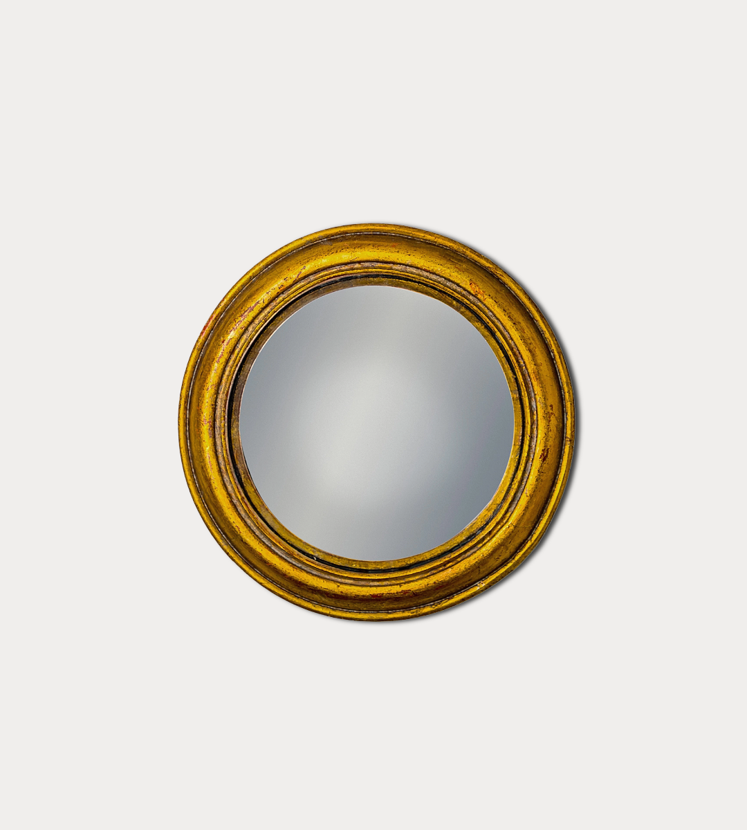 Round mirror with a gold frame on a white background