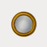 Round mirror with a gold frame on a white background