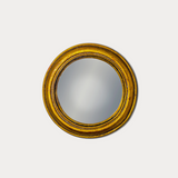 Round mirror with a gold frame on a white background