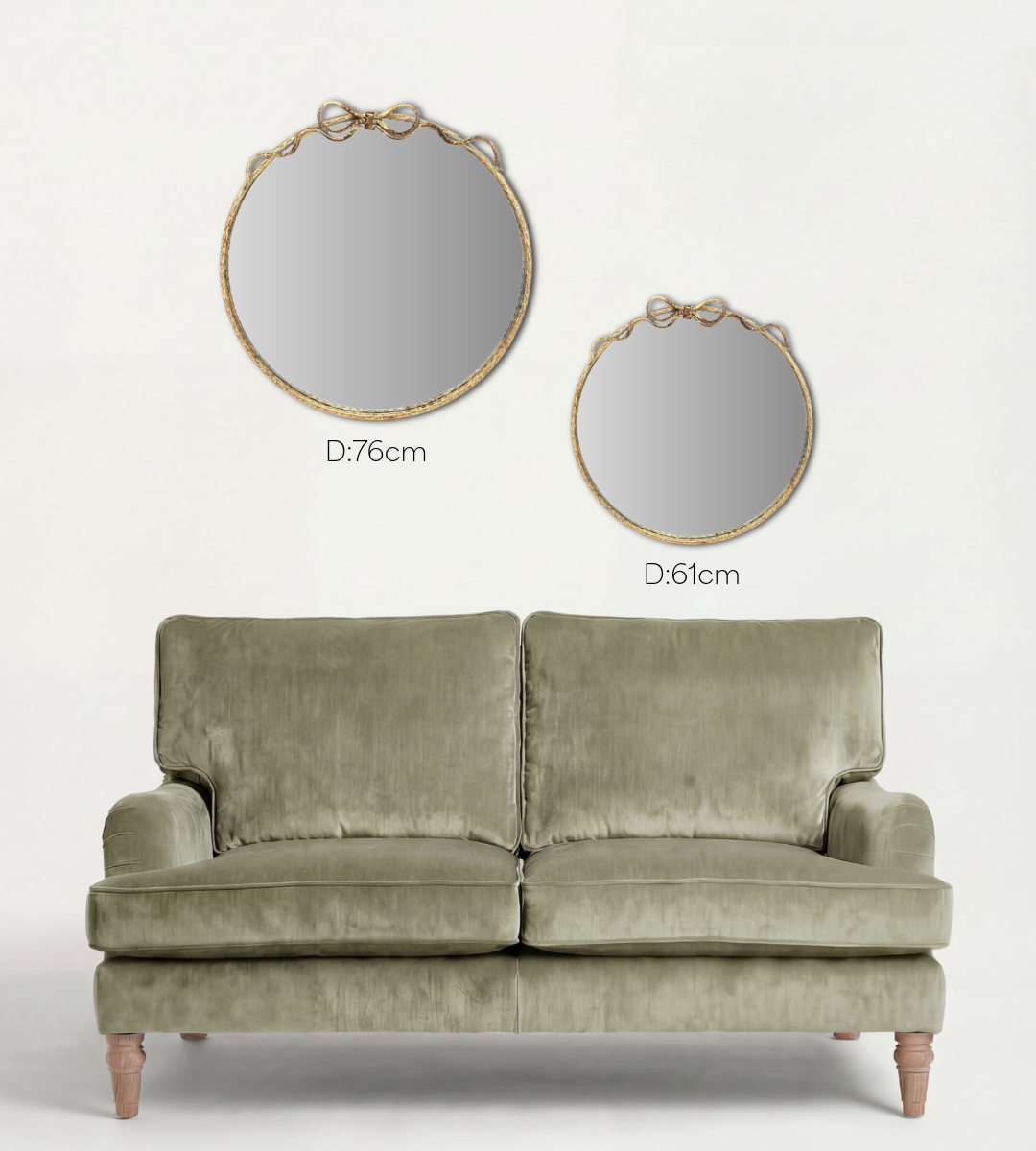 Two round mirrors with gold frames and two green sofas on a white background