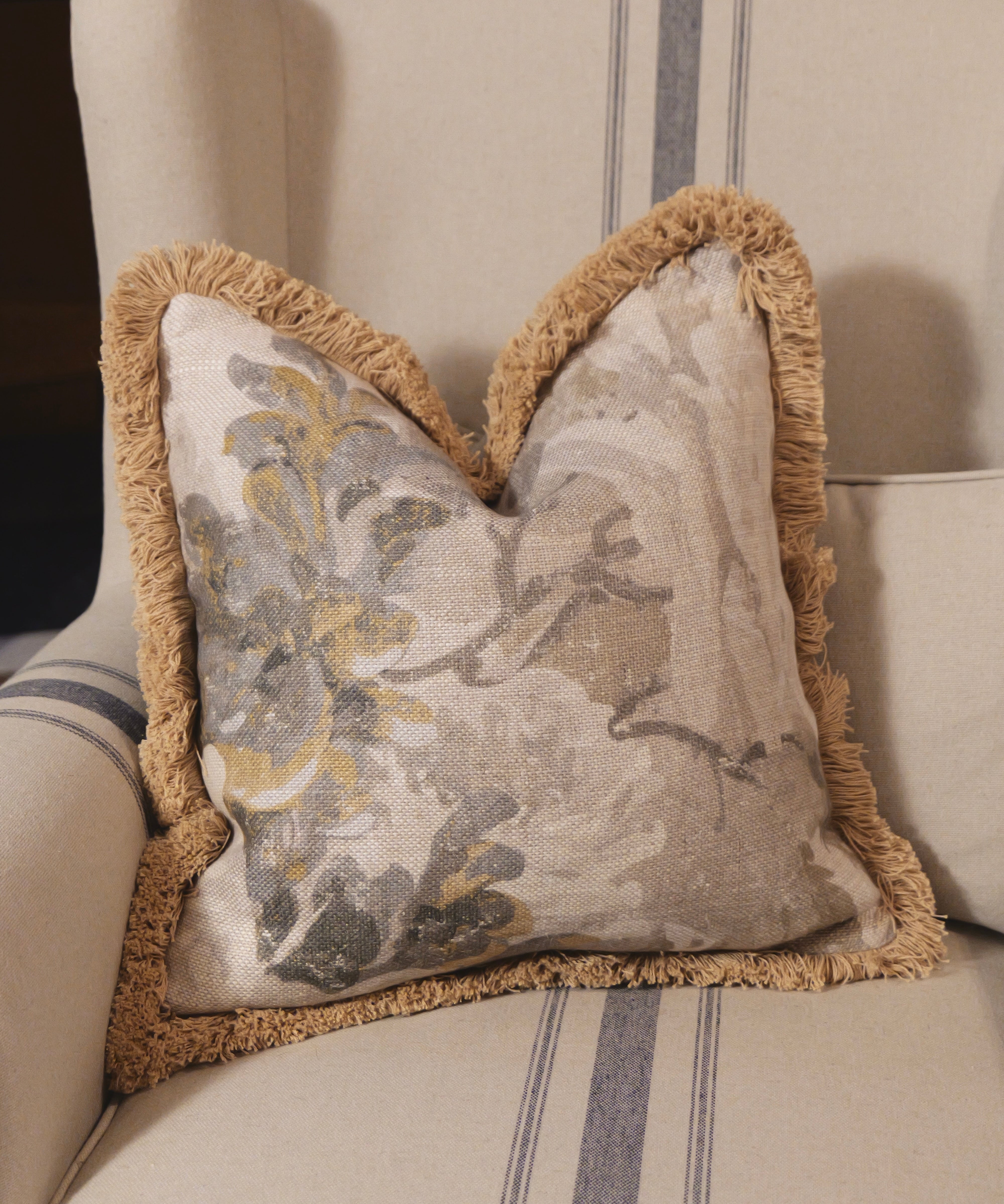 Decorative pillow with floral pattern on a striped sofa