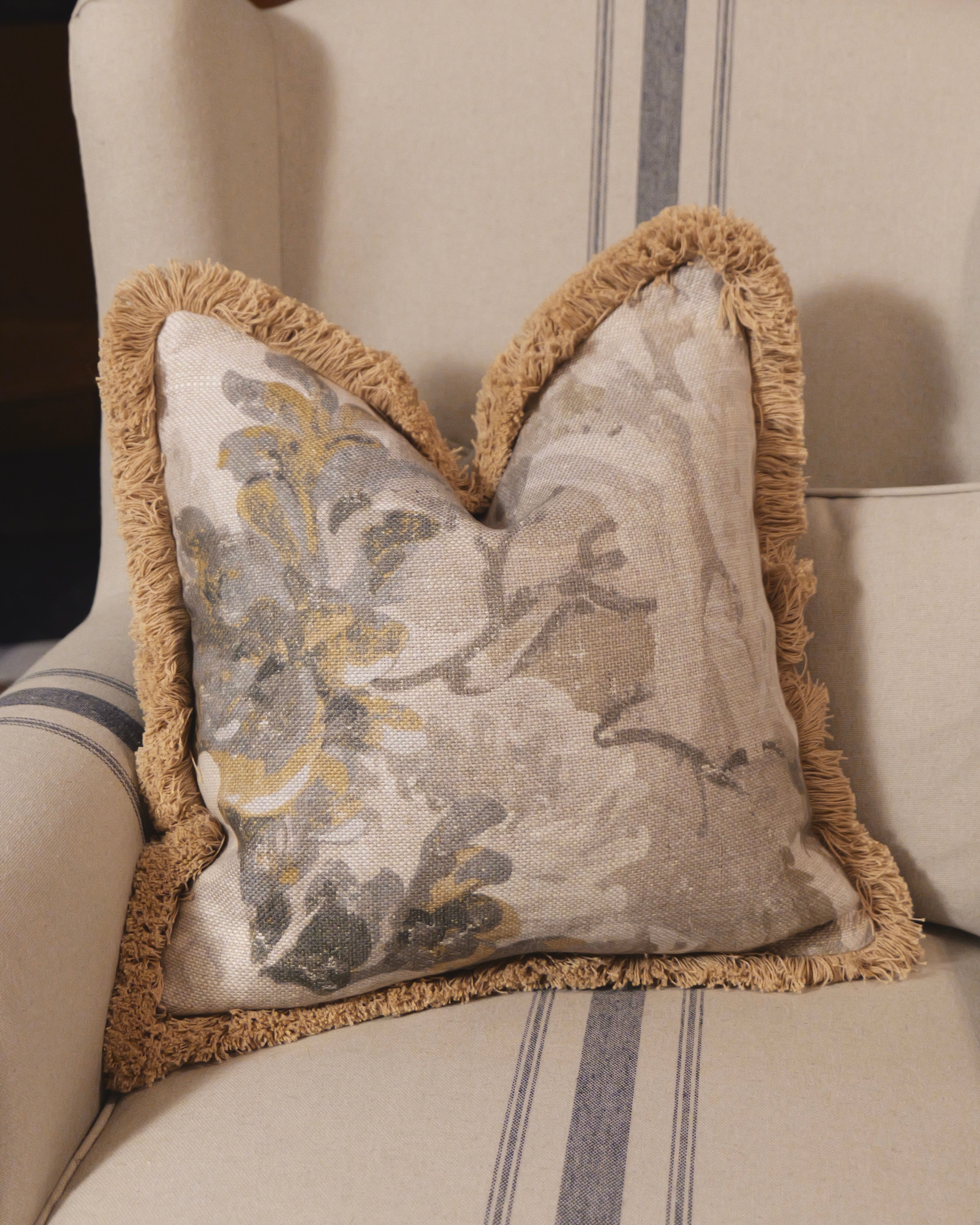 Decorative pillow with floral pattern on a striped sofa